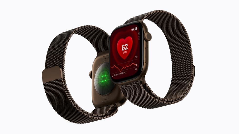 Two Apple Watch Series 12 devices shown side by side, with the sensors visible on the back of one and the Heart Rate app shown on the face of the other.