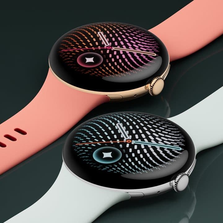 Two Google Pixel Watch 5 units showing the round Actua 360 display and knurled crown, in coral and light blue bands