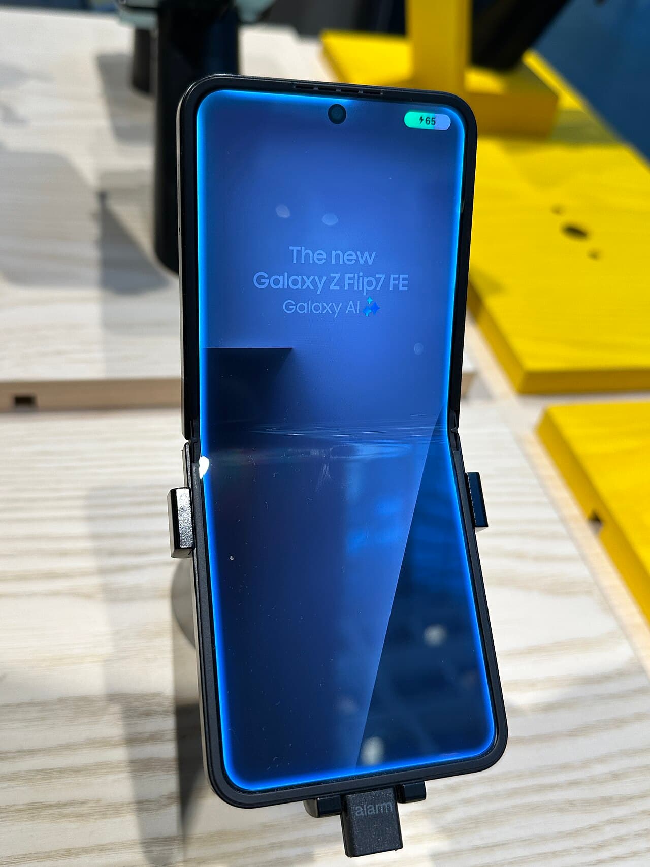 Galaxy Z Flip7 FE unfolded on an in-store display stand